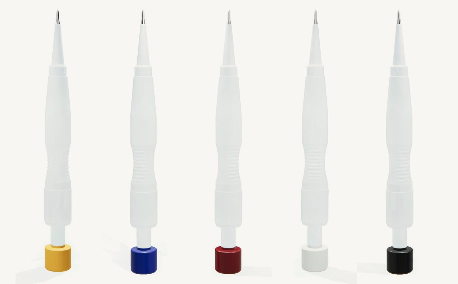Les stylos implanteurs DHI Garry dans leurs 5 tailles côte à côte, avec des capuchons jaune, bleu, rouge, blanc et noir de Ø 0,7 à 1,1 mm
